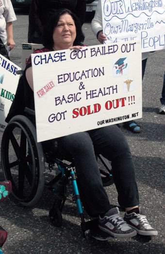 Melissa Stone protests the tax rebates going to the JPMorgan Case Bank while the Marysville School District is faced with budget cuts.