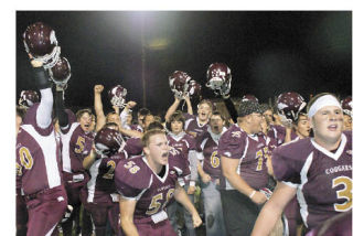 Lakewood players celebrate their win over King’s with helmets hoisted.