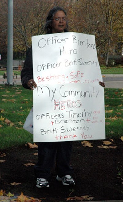 Seattle resident Leila Martinez holds a sign in honor of slain Seattle Police Officer Timothy Brenton outside the Key Arena in Seattle Nov. 6.