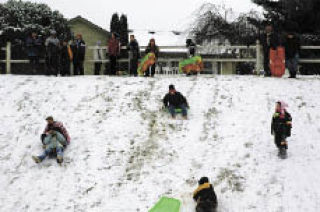 Adults and children alike sled down the slippery hill on the east side of Jennings Park Dec. 17.