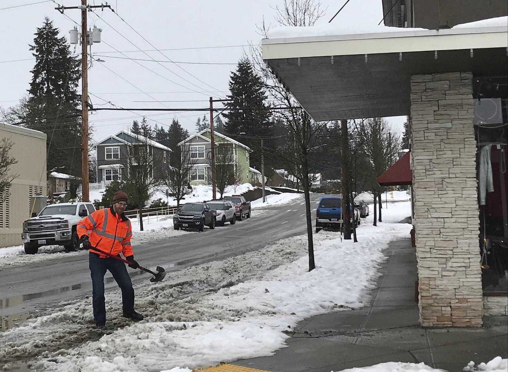 City of Arlington stormwater technician Nels Rasmussen clears the storm drain at 5th Street and Olympic Avenue. City officials encourage residents to help reduce flood risk and ponding by keeping storm grates near their home free of debris.